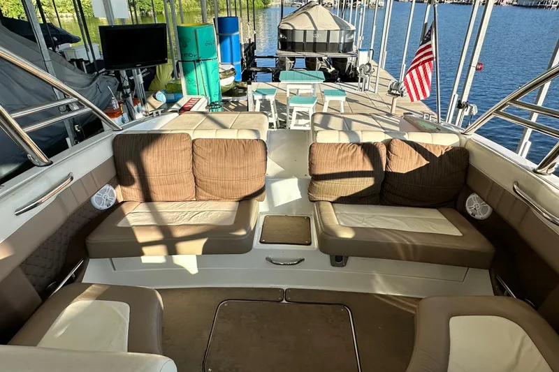Slide: The Image of Interior of a 2010 Cobalt 296 boat with cushioned seating and dock view. - 19