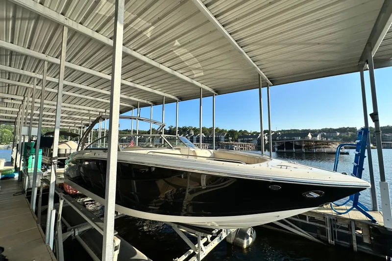 Slide: The Image of 2010 Cobalt 296 boat docked under a covered marina on a sunny day. - 3