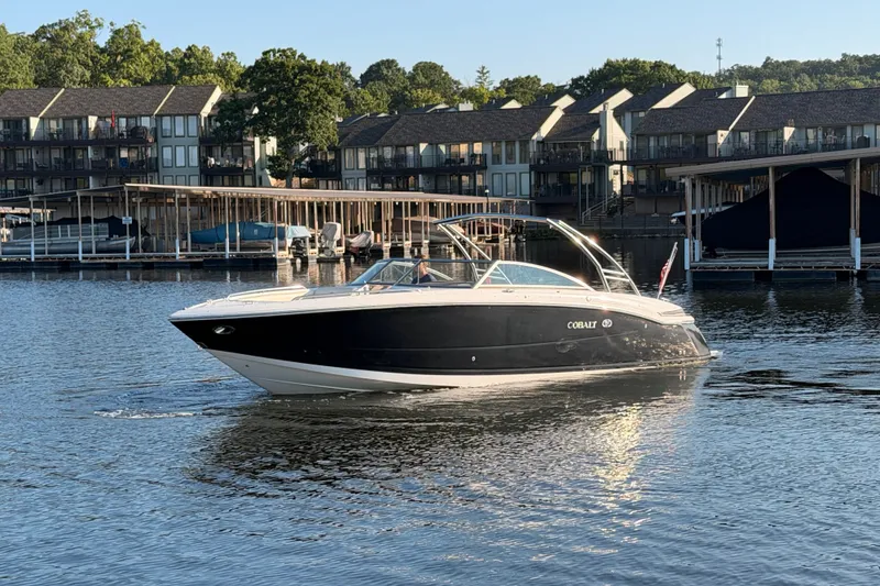 Slide: The Image of 2010 Cobalt 296 boat cruising on a lake near waterfront homes. - 26