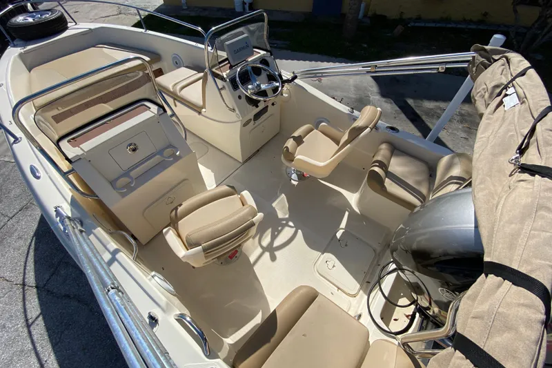 Slide: The Image of 2021 Scout 175 Sport Dorado boat interior with beige seating and steering console. - 4