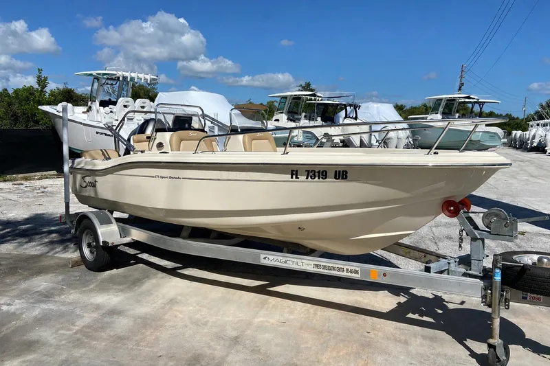 The Image of 2021 Scout 175 Sport Dorado boat on trailer, parked outdoors under blue sky. - 1