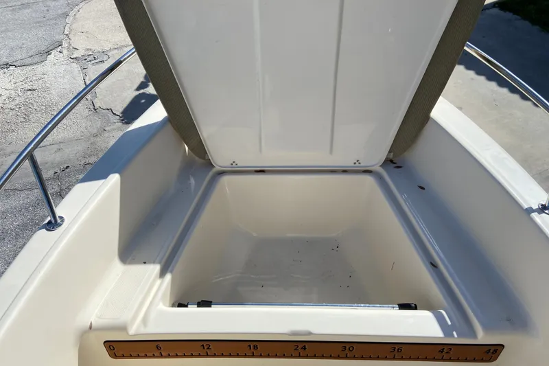 Slide: The Image of Open storage compartment on 2021 Scout 175 Sport Dorado boat, featuring a built-in measuring ruler. - 13