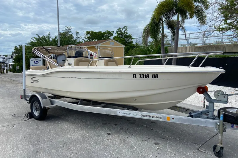 Slide: The Image of 2021 Scout 175 Sport Dorado boat on trailer, parked outdoors with palm trees. - 2