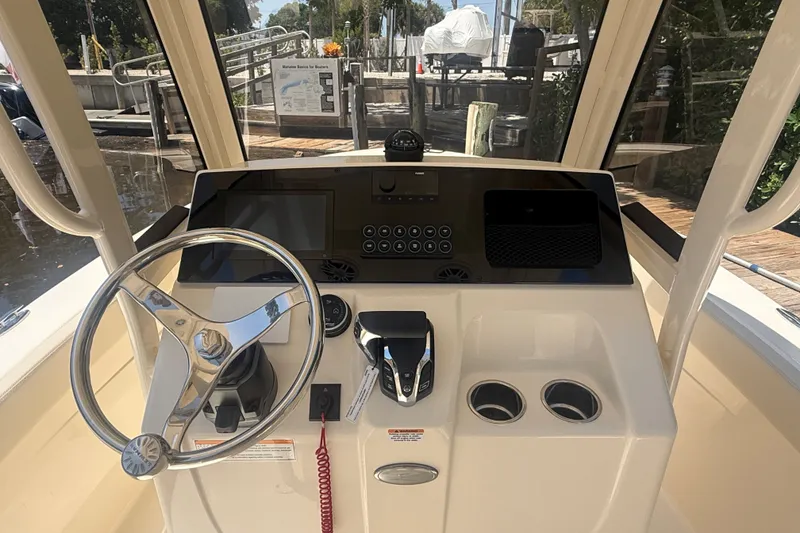 Slide: The Image of Helm of 2027 Scout 220 XSF boat with steering wheel and control panel. - 13