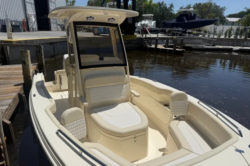 Slide: The Image of 2027 Scout 220 XSF boat docked, showcasing sleek design and spacious seating. - 18