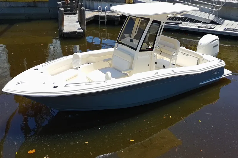 Slide: The Image of 2027 Scout 220 XSF boat docked in calm waters, featuring sleek design and modern amenities. - 2