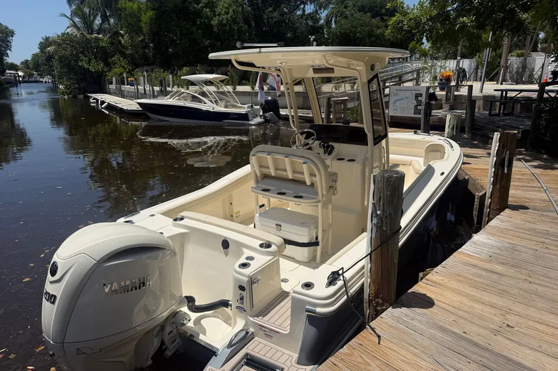 Slide: The Image of 2027 Scout 220 XSF boat docked by a wooden pier, featuring a Yamaha engine. - 8