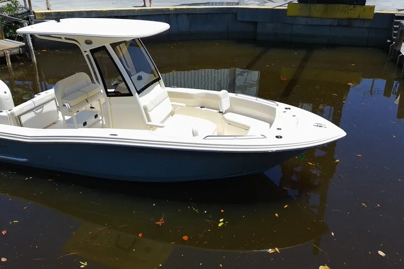 Slide: The Image of 2027 Scout 220 XSF boat docked in calm water, featuring sleek design and spacious seating. - 4
