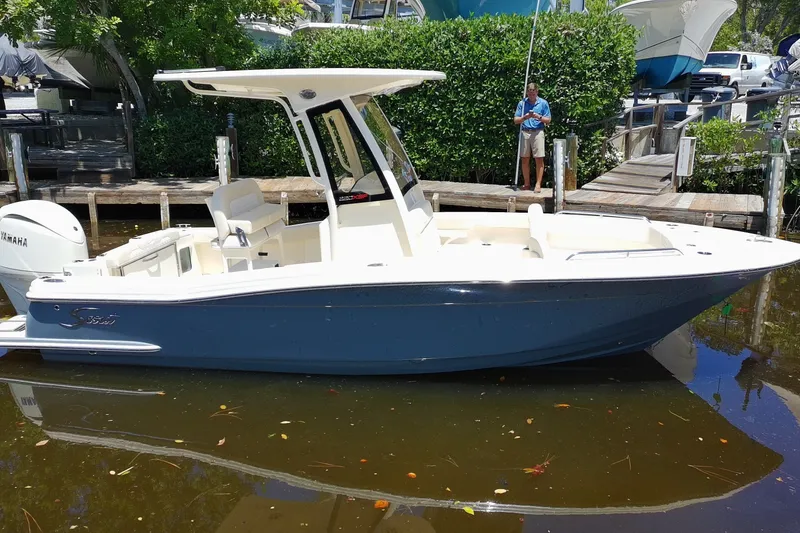 Slide: The Image of 2027 Scout 220 XSF boat docked, featuring sleek design and Yamaha engine. - 7