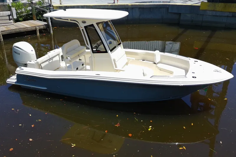 Slide: The Image of 2027 Scout 220 XSF boat with Yamaha engine, docked in calm water. - 6