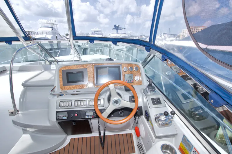 Slide: The Image of Cockpit of 2008 Formula 40 Performance Cruiser with modern navigation equipment and wooden steering wheel. - 23