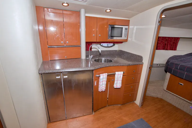 Slide: The Image of 2008 Formula 40 Performance Cruiser interior kitchen with wood cabinets and stainless steel appliances. - 34
