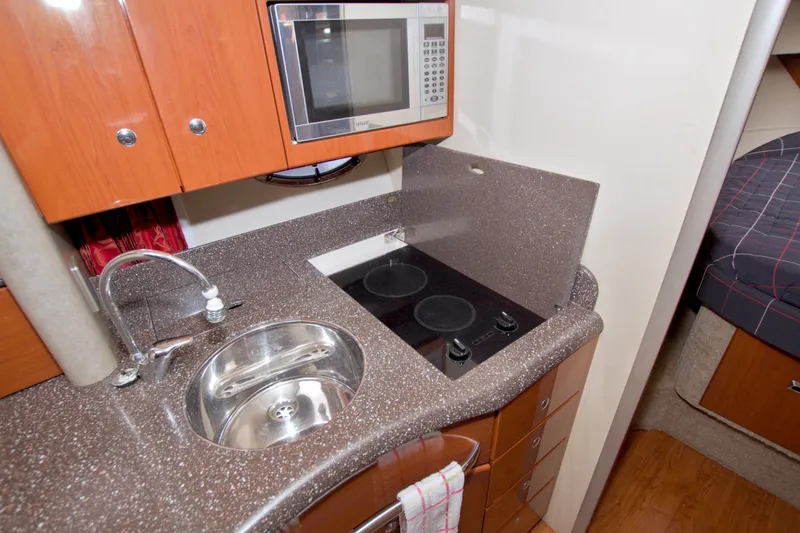 Slide: The Image of Compact kitchen in a 2008 Formula 40 Performance Cruiser with sink, stove, and microwave. - 35