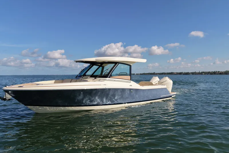 The Image of 2027 Chris-Craft Calypso 32 boat on calm water under a clear blue sky. - 0