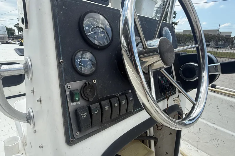 Slide: The Image of Console of a 2004 Carolina Skiff 17 DLX with steering wheel and gauges. - 14