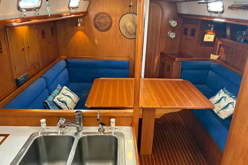 Slide: The Image of Luxurious 1989 Cambria 44/46 yacht interior with blue seating, wooden table, and dual sinks. - 18
