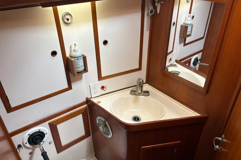 Slide: The Image of Compact 1989 Cambria 44/46 yacht bathroom with sink, mirror, and wooden cabinetry. - 28