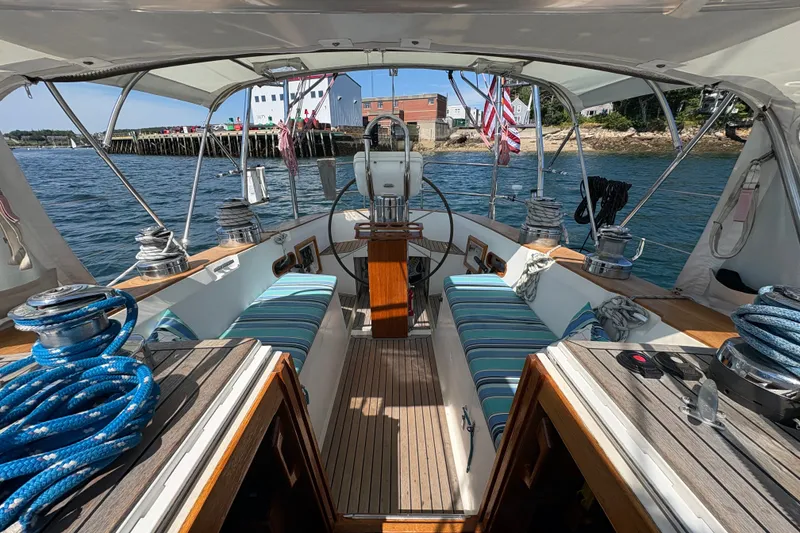 Slide: The Image of Cockpit view of 1989 Cambria 44/46 sailboat with striped cushions and nautical equipment. - 2