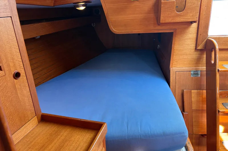 Slide: The Image of Cozy wooden cabin interior with blue mattress on a 1989 Cambria 44/46 sailboat. - 24