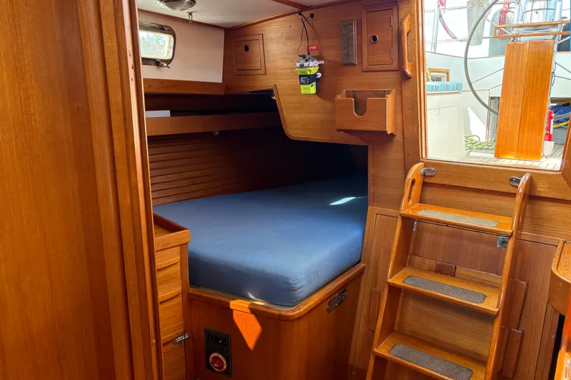 Slide: The Image of Cozy wooden cabin interior of 1989 Cambria 44/46 sailboat with blue mattress and ladder. - 23
