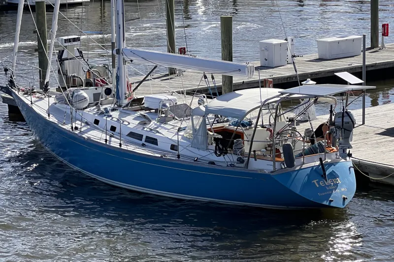 Slide: The Image of Blue 1989 Cambria 46 sailboat docked at marina, reflecting on water. - 7