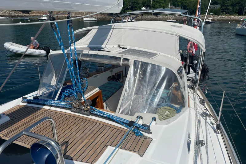 Slide: The Image of 1989 Cambria 44/46 sailboat with white canopy, docked in calm waters. - 15