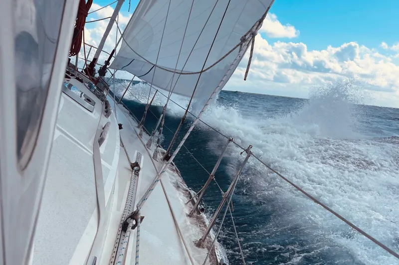 Slide: The Image of Sailing on a 1989 Cambria 46 yacht, cutting through ocean waves under a clear blue sky. - 10