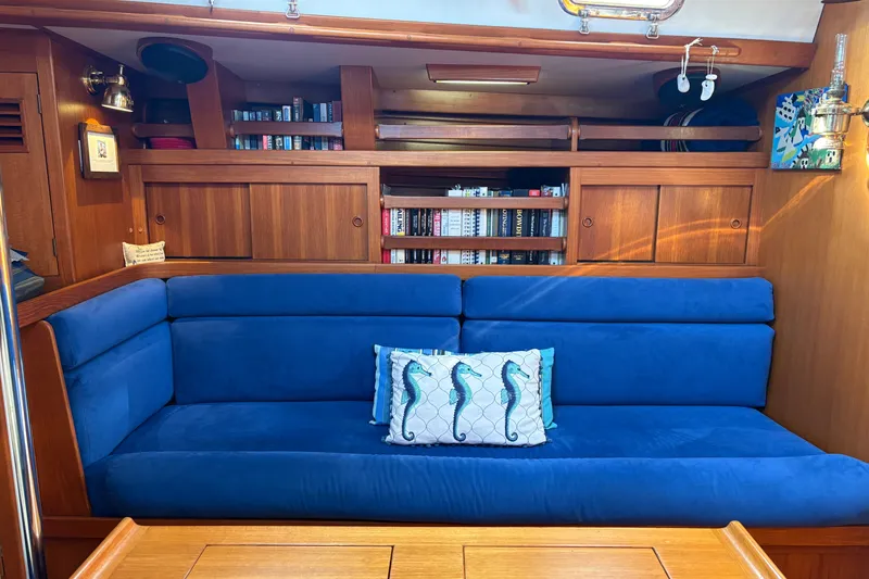Slide: The Image of Cozy yacht interior with blue sofa, seahorse pillow, and wooden shelves. Cambria 44/46, 1989. - 22