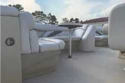 Slide: The Image of 2017 SMOKERCRAFT boat interior with white seating and table, under a clear sky. - 10
