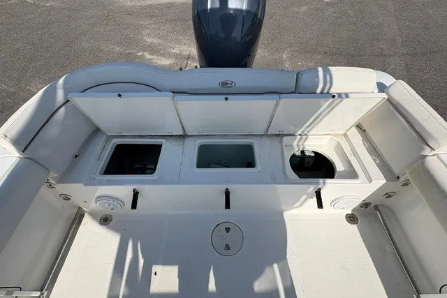 Slide: The Image of 2020 Sea Hunt Ultra 225 boat deck with storage compartments and engine view. - 7