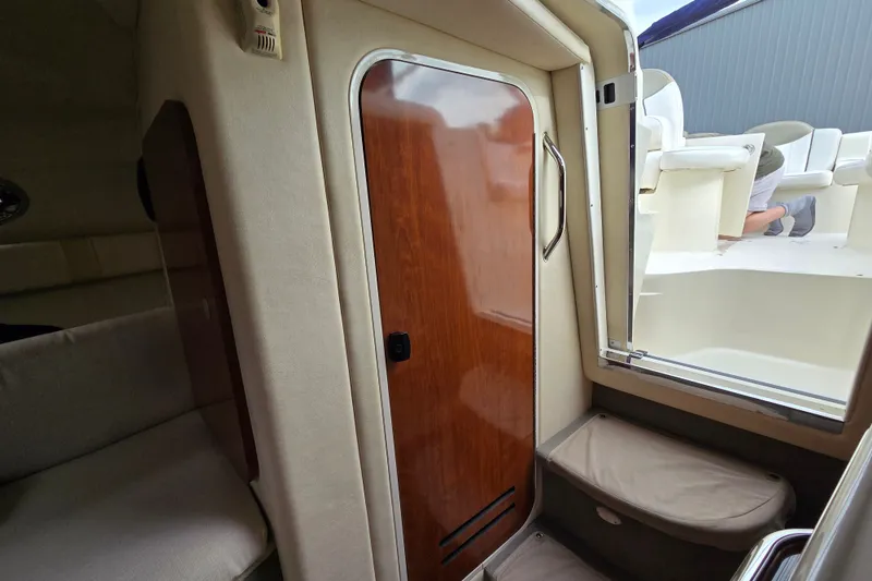 Slide: The Image of Interior cabin view of 2006 Sea Ray 240 Sundancer boat with wooden door and seating. - 49