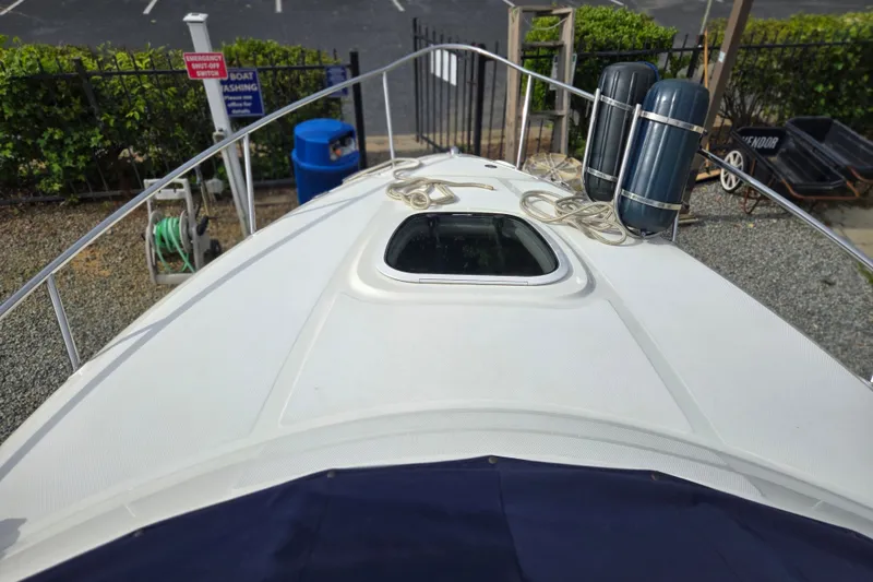 Slide: The Image of Bow view of 2006 Sea Ray 240 Sundancer with ropes and hatch, docked. - 15