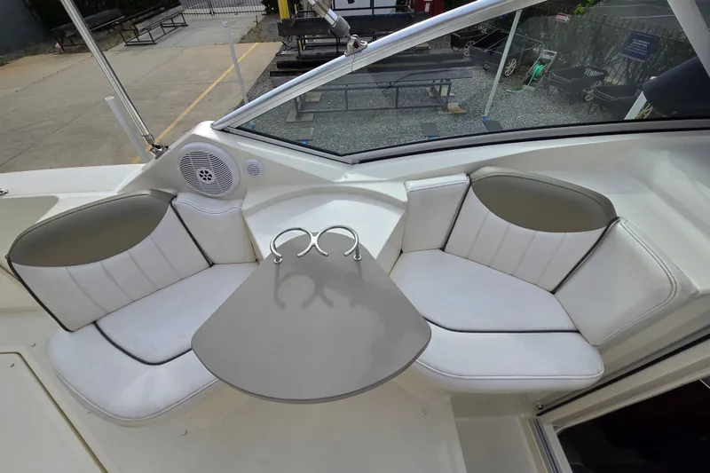 Slide: The Image of 2006 Sea Ray 240 Sundancer boat interior with white seating and a small table. - 21