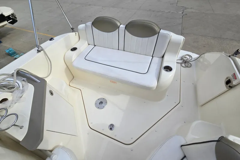 Slide: The Image of 2006 Sea Ray 240 Sundancer boat interior with white seating and cup holders. - 19