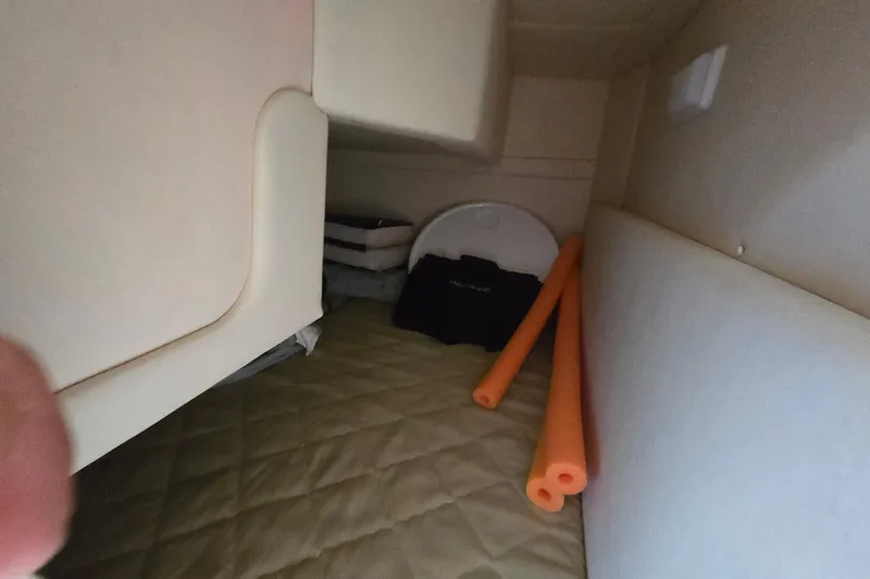 Slide: The Image of Interior cabin of 2006 Sea Ray 240 Sundancer with storage items and orange pool noodles. - 43