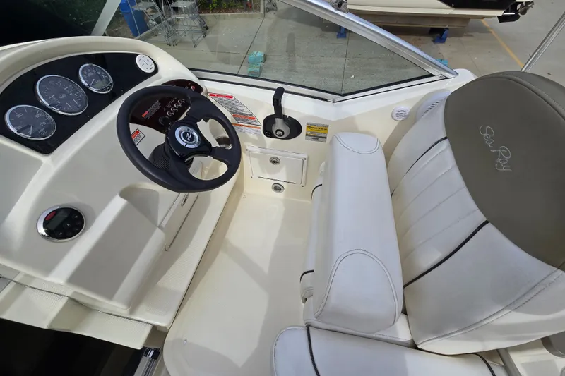 Slide: The Image of 2006 Sea Ray 240 Sundancer cockpit with steering wheel and gauges. - 26