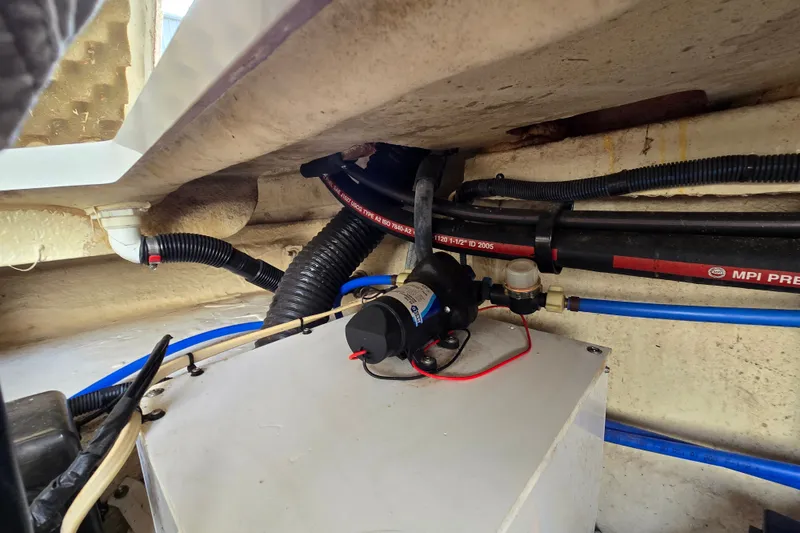 Slide: The Image of Engine compartment of a 2006 Sea Ray 240 Sundancer with visible wiring and hoses. - 38