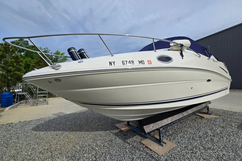 The Image of 2006 Sea Ray 240 Sundancer boat on trailer, parked outdoors. - 0