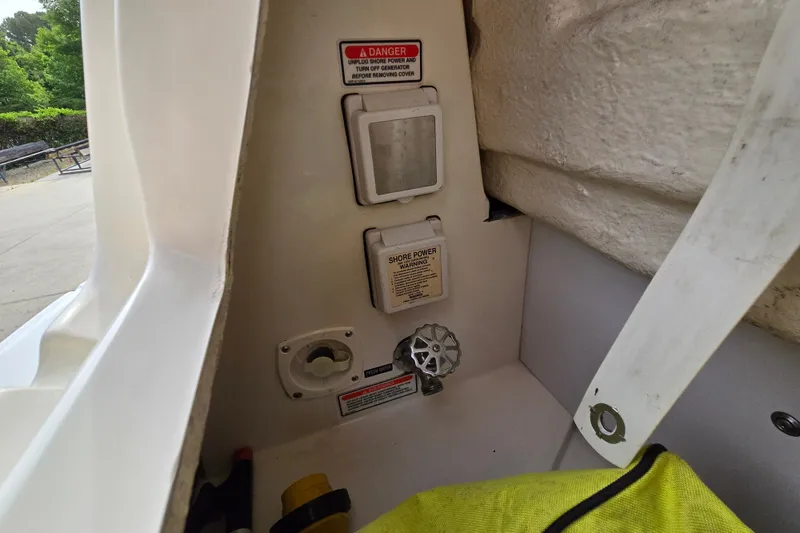 Slide: The Image of 2006 Sea Ray 240 Sundancer shore power connection and warning labels in boat compartment. - 41