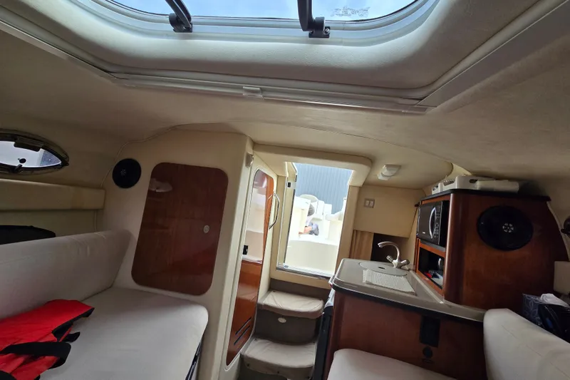 Slide: The Image of Interior of 2006 Sea Ray 240 Sundancer boat with seating, kitchenette, and skylight. - 50
