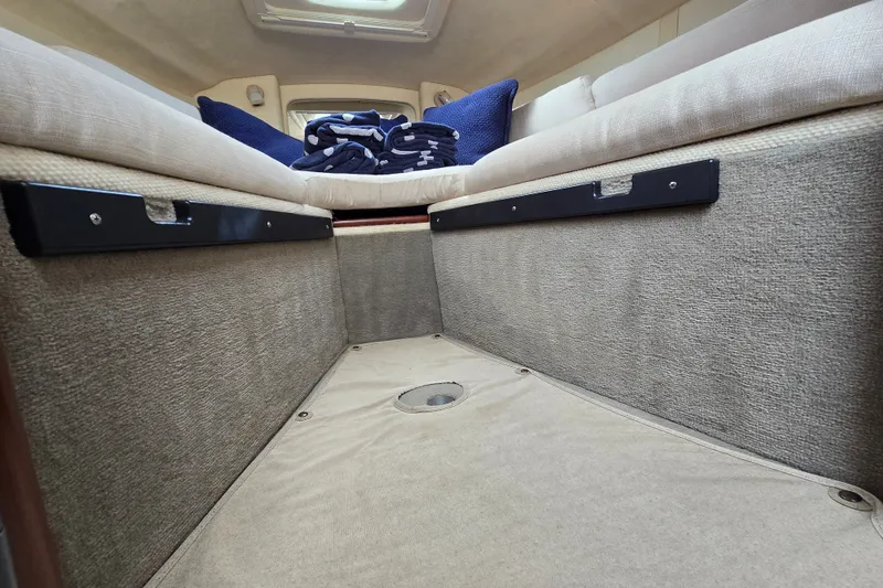 Slide: The Image of Interior cabin of 2006 Sea Ray 240 Sundancer with beige upholstery and blue pillows. - 55