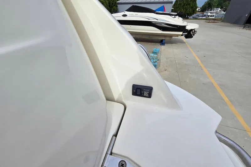 Slide: The Image of 2006 Sea Ray 240 Sundancer boat detail with docked vessels in background. - 25