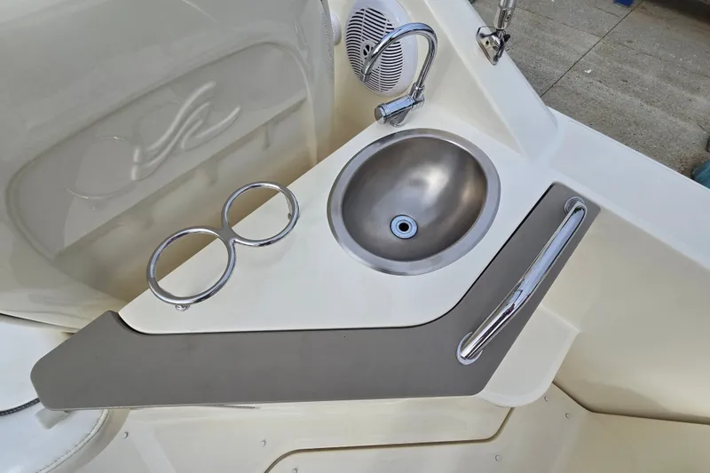 Slide: The Image of 2006 Sea Ray 240 Sundancer boat sink area with stainless steel basin and cup holders. - 20