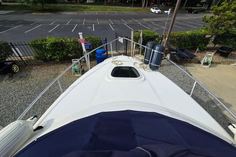 Slide: The Image of 2006 Sea Ray 240 Sundancer boat docked, view from bow, parking lot in background. - 17