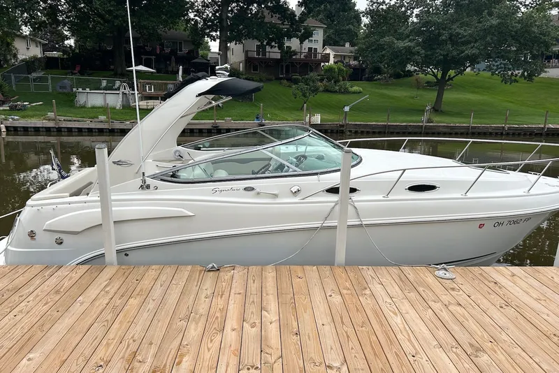 The Image of 2008 Chaparral Signature 280 boat docked by a wooden pier, surrounded by greenery. - 0