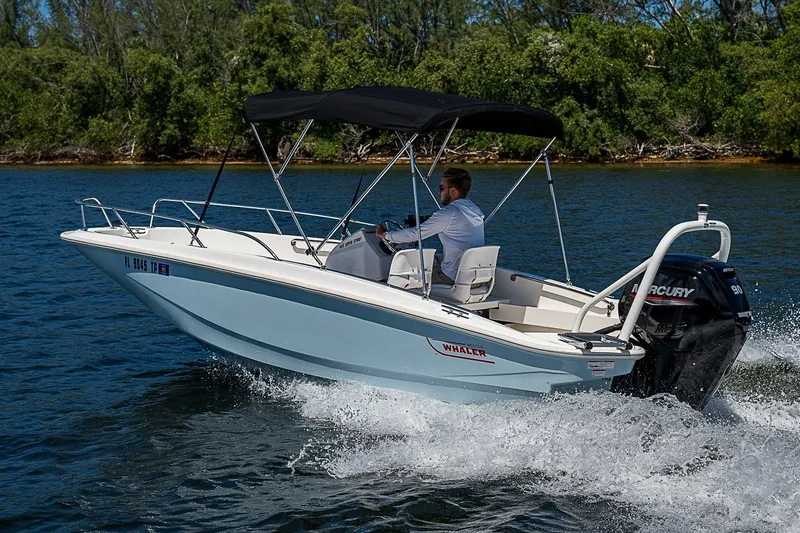 Slide: The Image of 2022 Boston Whaler 160 Super Sport cruising on a lake with lush greenery. - 27
