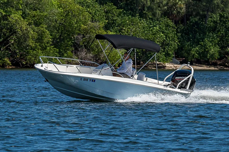 Slide: The Image of 2022 Boston Whaler 160 Super Sport cruising on a lake with lush green trees. - 38