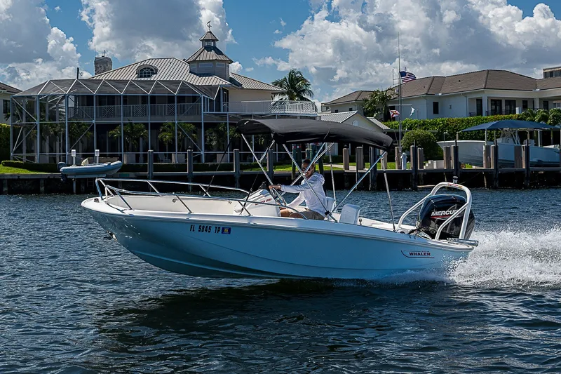Slide: The Image of 2022 Boston Whaler 160 Super Sport cruising on a sunny day near waterfront homes. - 34