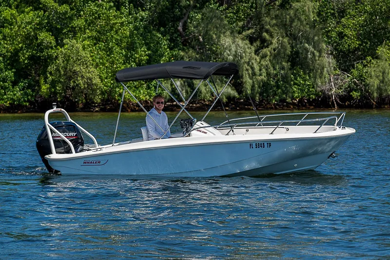 Slide: The Image of 2022 Boston Whaler 160 Super Sport boat cruising on a sunny day with lush greenery background. - 20
