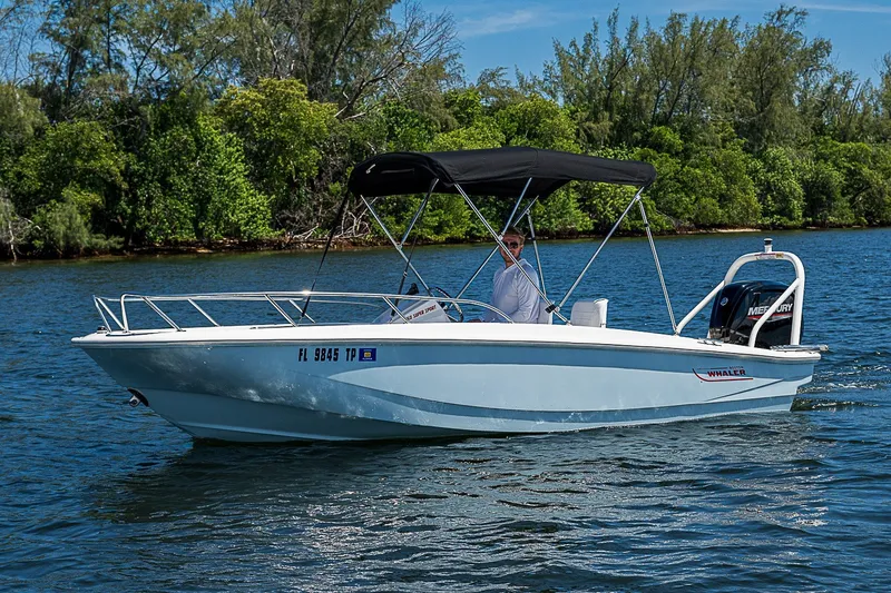 Slide: The Image of 2022 Boston Whaler 160 Super Sport boat cruising on a scenic lake. - 11